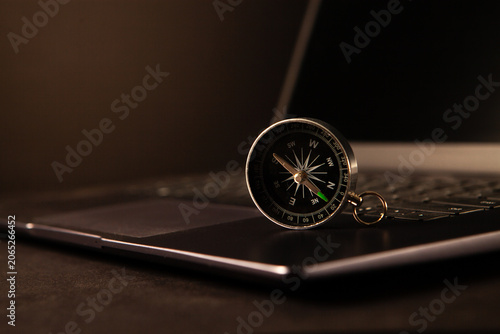 Compass on a laptop keyboard. Business and travel concept.