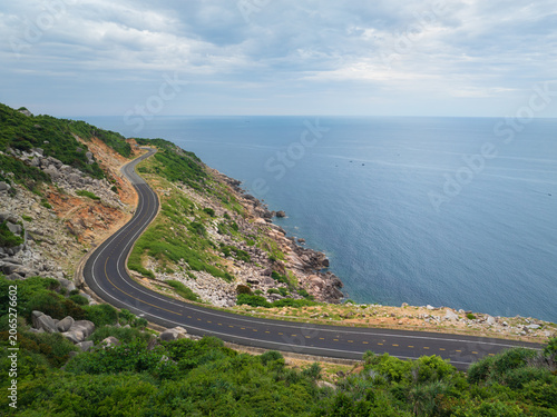 Scenic coastal road winding along rocky shoreline and open sea near Song Cau town, Dak Lak province, Vietnam.