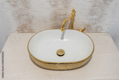 Slika na platnu Modern ceramic sink with golden faucet on marble countertop Close view of decora