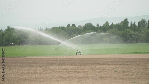 A stateoftheart modern irrigation system is efficiently watering crops in a lush green agricultural field