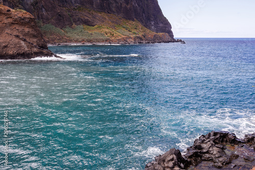 Valokuva Turquoise waters of the Atlantic Ocean between high cliffs, cloudy sky and high rocks, Madeira, Portugal