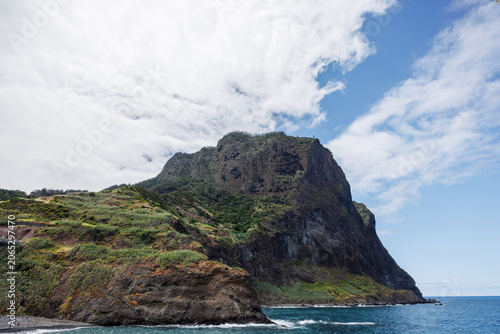 Valokuva High cliffs covered with tropical vegetation in the Atlantic Ocean against a cloudy sky, Madeira, Portugal