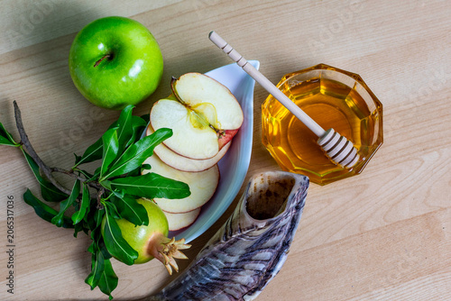 Rosh hashanah symbols with apple slices, honey, pomegranate, shofar horn