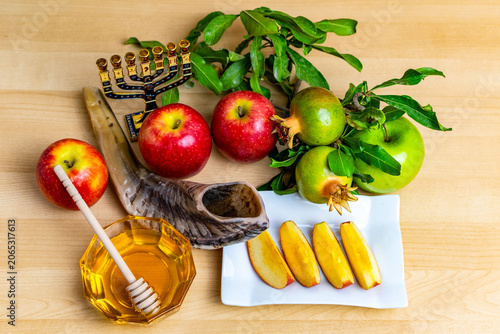 Rosh hashanah symbols with shofar, apples, honey, and pomegranate