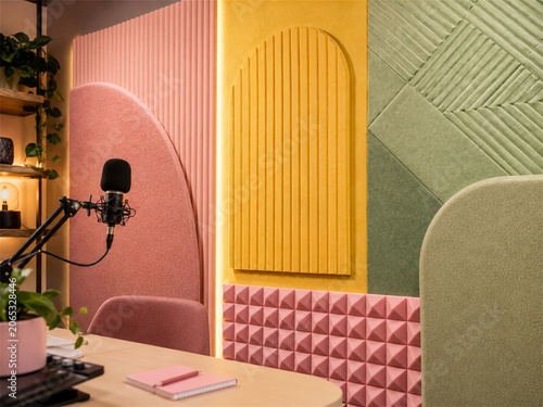 Colorful podcast studio with pastel acoustic wall panels desk microphone soft chair plants and warm ambient lighting creating a cheerful creative space for recording audio and content