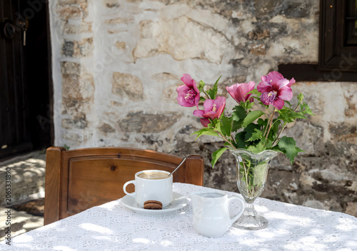 Still life with hibiscus and a cup of coffee on the table close-up