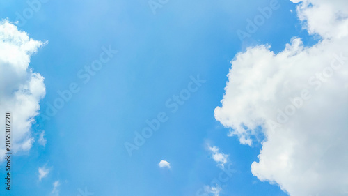 bright blue sky with fluffy white clouds on a sunny day, perfect for background or wallpaper.