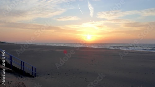 Cinematic sunset over the North Sea at the Belgian coast in Nieuwpoort with empty sandy beach and stairs