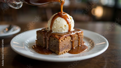 Delicious chocolate cake with ice cream and caramel sauce being poured on top