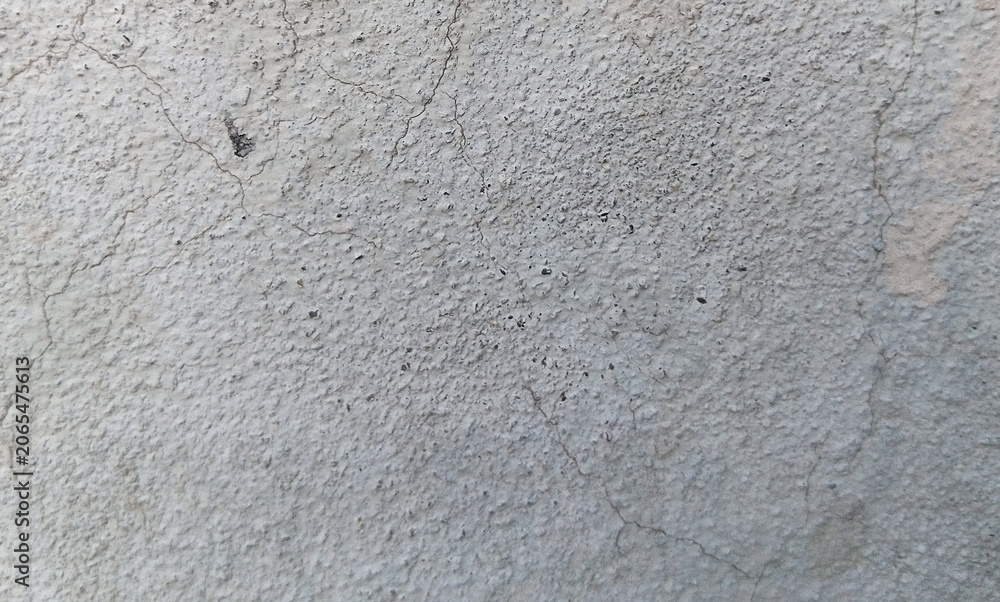 Fototapeta premium Weathered concrete wall texture with fine cracks, industrial gray cement surface background, gritty stone plaster material for architectural design