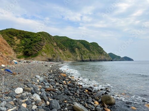 Aerial view of the rugged coastline and beautiful blue sea at Cape Tsutsuzaki on Tsushima Island, Nagasaki Prefecture, Japan.