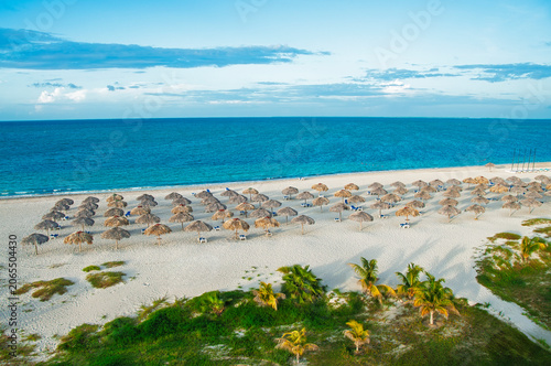 Photography Varadero beach resort with palapa umbrellas and turquoise sea in Cuba