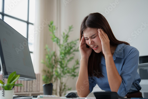 Vászonkép Young Asian business woman battling severe headache and migraine due to work pre