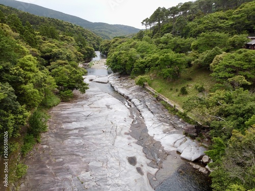The suspension bridge and unique granite riverbed with potholes at Ayumodoshi Natural Park on Tsushima Island, Nagasaki Prefecture, Japan.