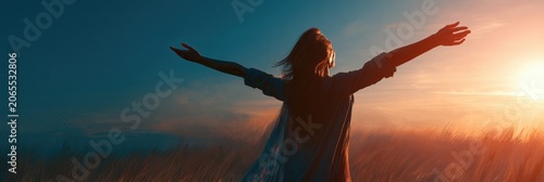 A silhouette of a mature woman stands with arms wide in a large open space at sunset, feeling liberated and embracing a new chapter in life.