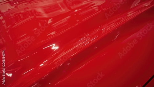 Glossy red car surface with reflections and highlights