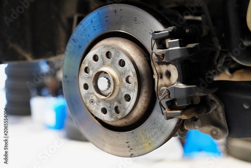 Brake disc and caliper close-up during car maintenance in auto repair garage