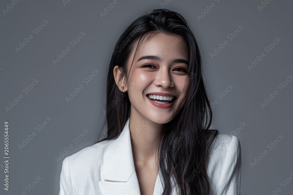 Obraz premium Smiling Asian woman in a white blazer creates a clean, modern visual suitable for professional branding, corporate identity, and beauty advertising.