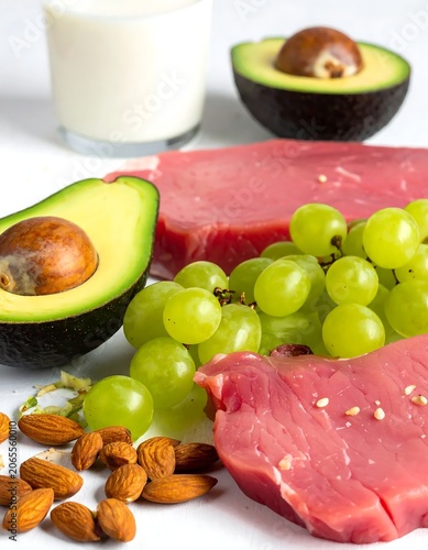 Fresh Raw Tuna Steaks with Avocado Grapes and Almonds on White Surface