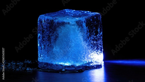 Glowing blue ice cube with internal swirl on dark surface