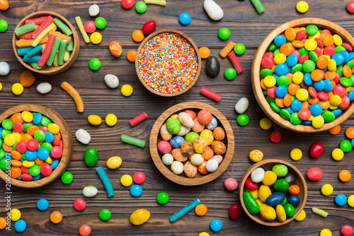 Fotografie different colored round candy in bowl and jars