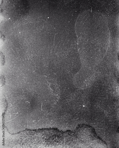 Blank grained film strip texture background with heavy grain, dust and light leak. Old expired soviet moldy photographic film scan. Black and white.