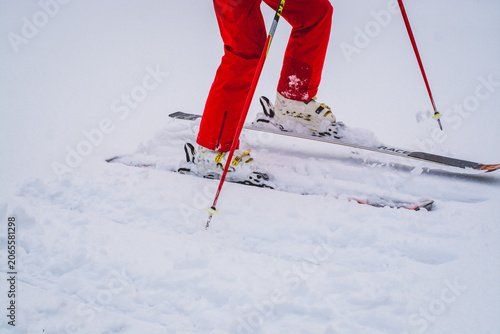 Tableau sur toile Skiing on snowy mountain slope with red ski pants and equipment mountain equipme
