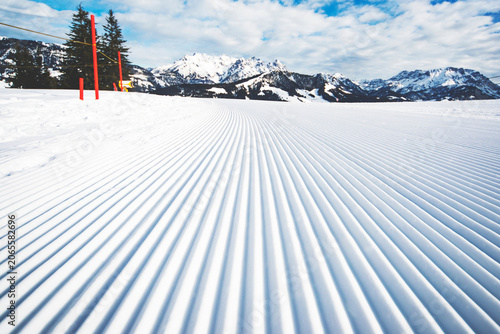 Tableau sur toile Freshly groomed corduroy snow tracks on a ski run slope with corduroy mountains