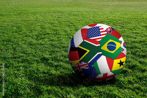 Foto Single soccer ball with world flags design resting on green grass turf football
