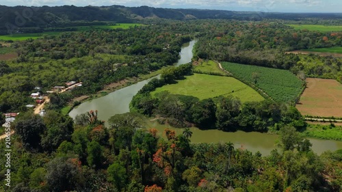 Aerial View of Tropical River Winding Through Lush Farmland and Forest