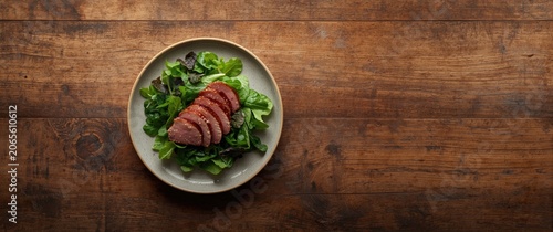 Sliced meat on a bed of fre...