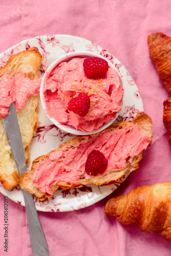 Raspberry butter spread on fresh croissants