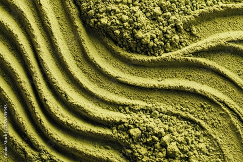Close up of vibrant green matcha powder with detailed texture showing wavy patterns and granular consistency under soft lighting creating an artistic abstract background