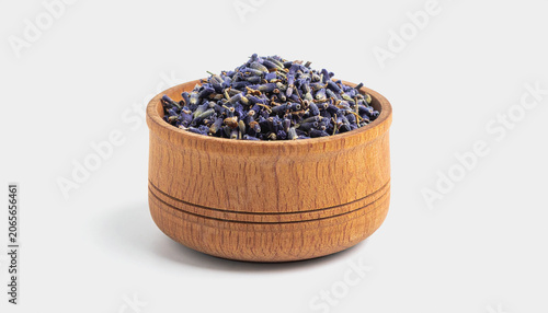 A wooden bowl filled with dried lavender buds sits on a plain white background, showcasing its natural texture and color contrast.