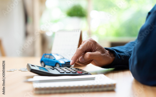 Fotografi Auto loan calculation and vehicle financing concept with calculator, car model, coins, and payment schedule, representing budgeting, loan repayment, ownership costs, and personal financial planning