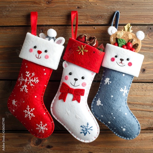 Three colorful Christmas stockings with animal faces and snowflakes