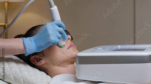 Clinical facial treatment progression showing practitioner scanning face with handheld transducer