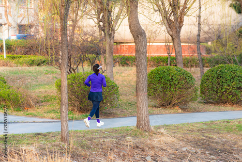 People walking and taking photos on riverside boardwalk in vibrant spring park