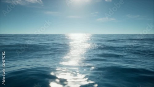 Sunny seascape calm blue ocean ripples under a bright sky, shimmering sunlight reflecting off the water