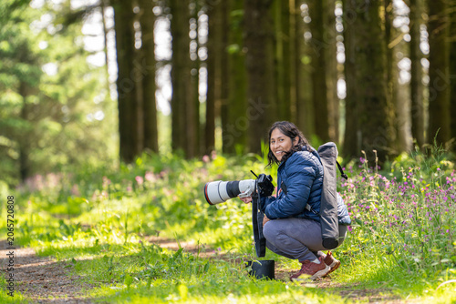 Canvastavla Title (Adobe Stock)
Female wildlife photographer with telephoto lens in forest d