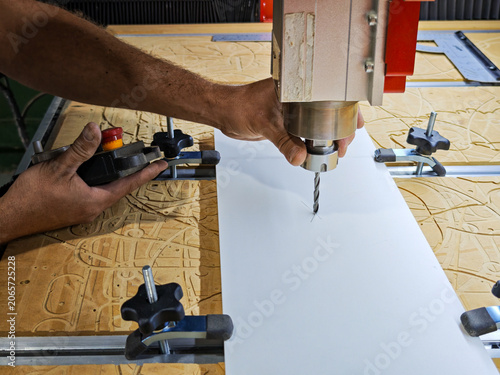 Close up of worker hands calibrating CNC milling machine for cutting process