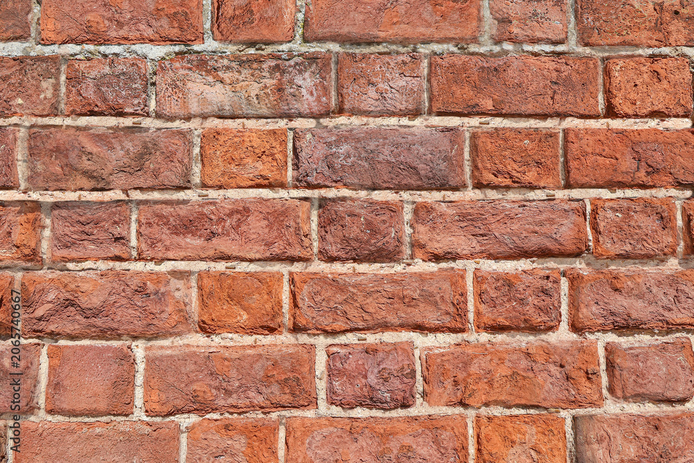 Fototapeta premium A red brick wall in closeup background