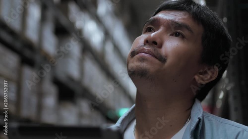 Thoughtful Warehouse Employee Evaluating Inventory and Logistics Tasks. Decision making, warehouse planning, logistics analysis