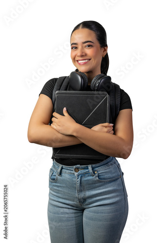 Smiling young hispanic female college student wearing headphones and carrying a backpack while holding a digital tablet against a white background