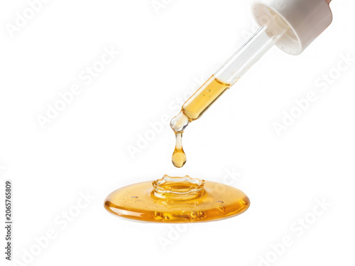 Pipette dropping golden yellow liquid isolated on transparent background