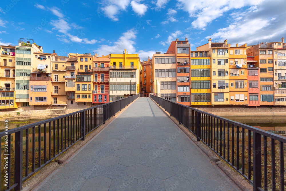 Fototapeta premium Colorful historic houses reflected in the Onyar River with cathedral towers rising above the skyline in Girona, Catalonia, Spain.
