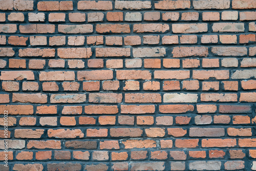 Vintage terracotta brickwork pattern, grunge wall background for design. Detailed view of an old rugged brick wall surface, loft interior concept.