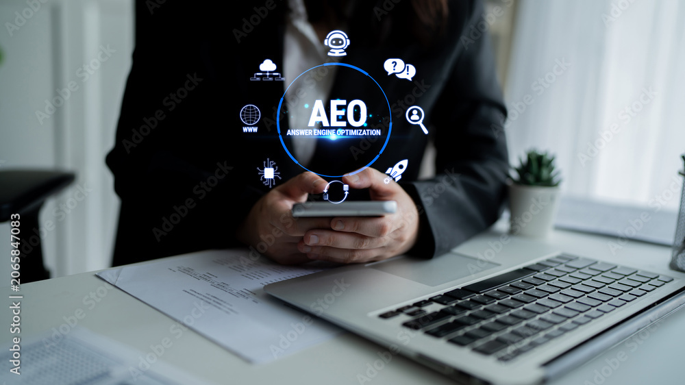 Obraz premium Professional Business Person Using Smartphone for Search Engine Optimization Techniques with AEO Concept and Digital Icons in Modern Office Environment Fluxor.