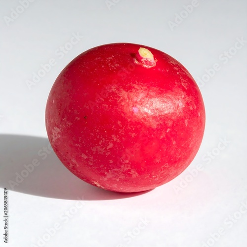 Fresh red apple with water droplets on white surface.