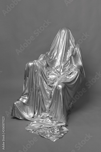Psychological horror ghost figure covered in silver drape.